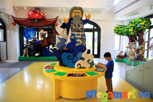 Một cậu bé đang vui chơi cùng mô hình Lego trong buổi lễ khai trương