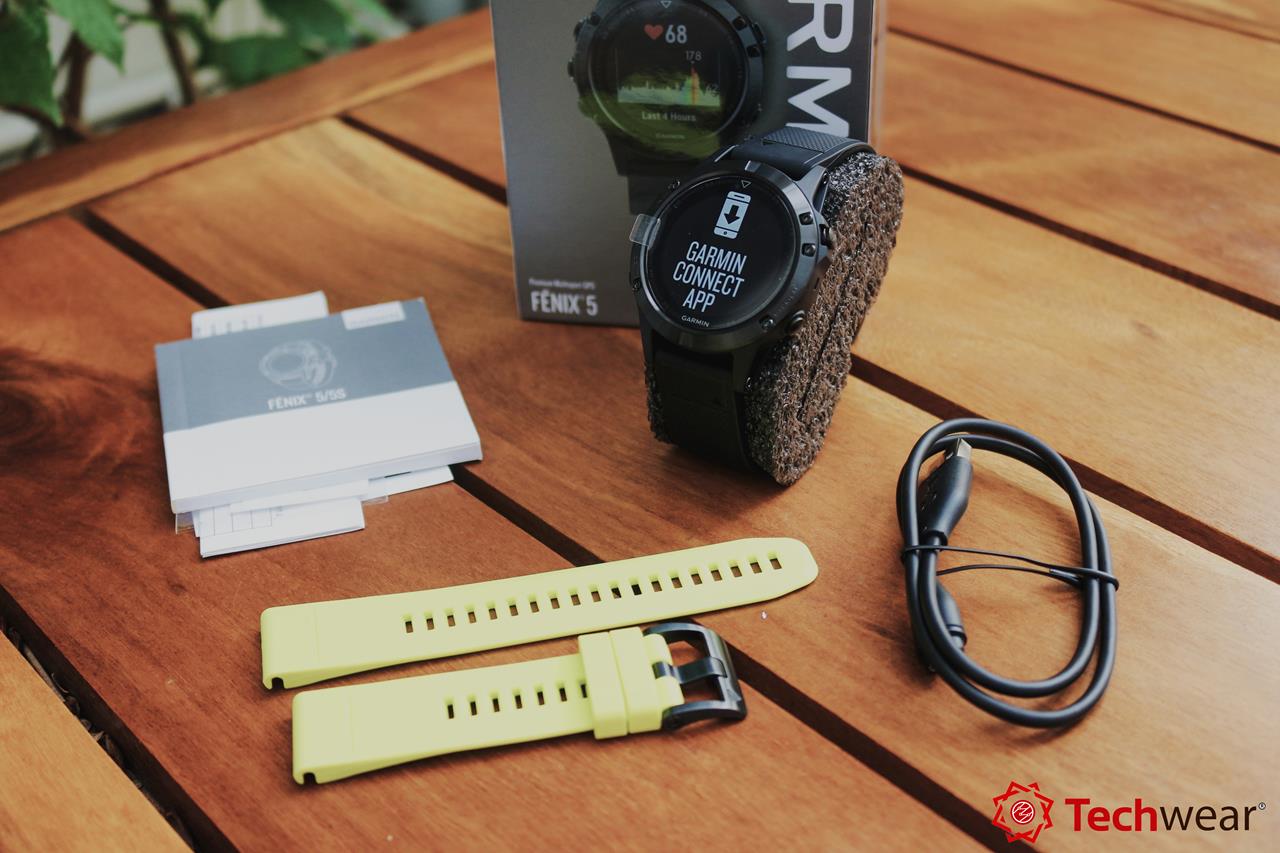 Bên trong hộp bao gồm: Đồng hồ Fenix 5 phiên bản Sapphire hoàn chỉnh, dây sạc, dây đeo silicon màu vàng tặng kèm, sổ tay hướng dẫn sử dụng và sticker dán độc quyền sản xuất của Garmin.