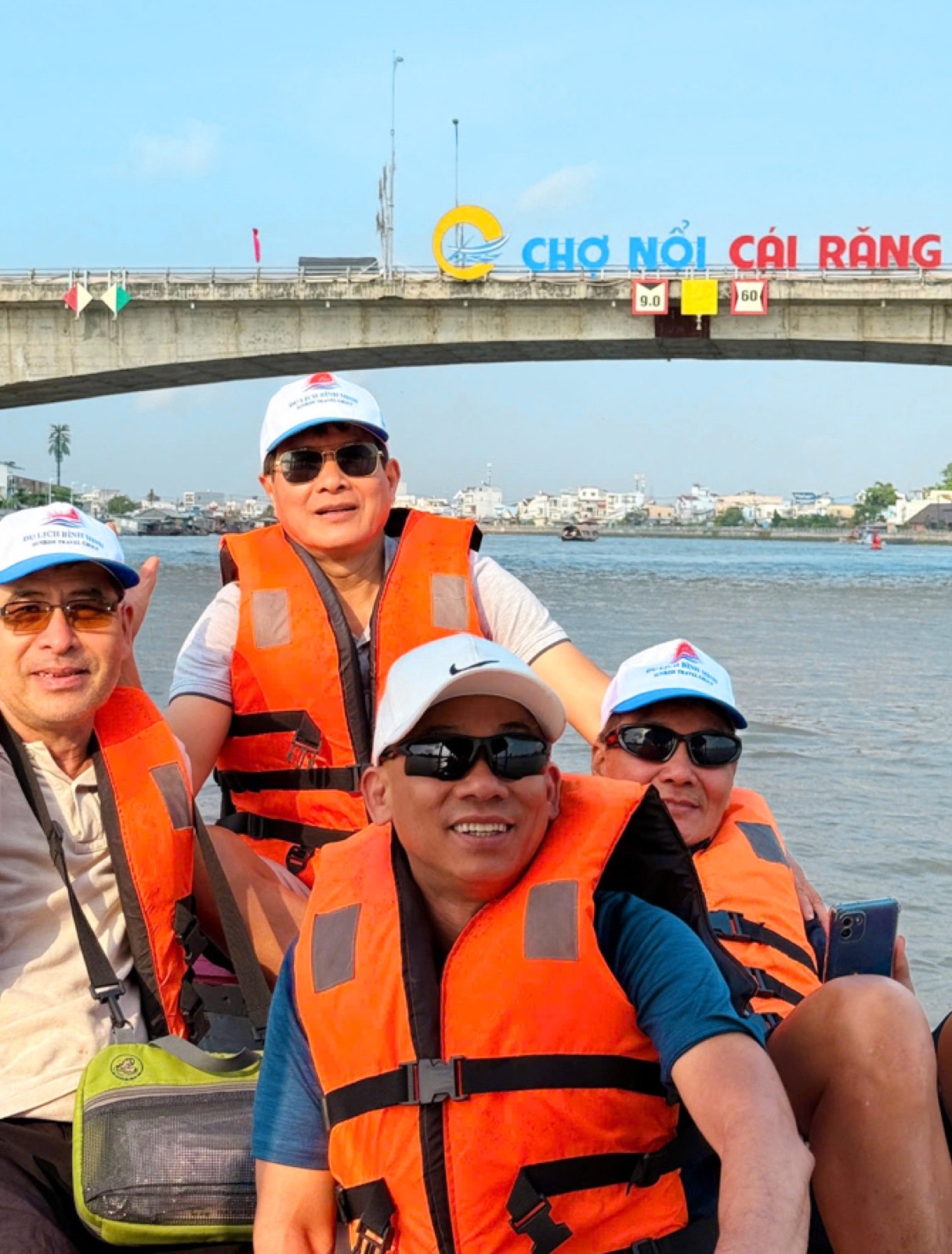 Nhóm du khách đội mũ Du Lịch Bình Minh đi thuyền dưới chân cầu Cái Răng