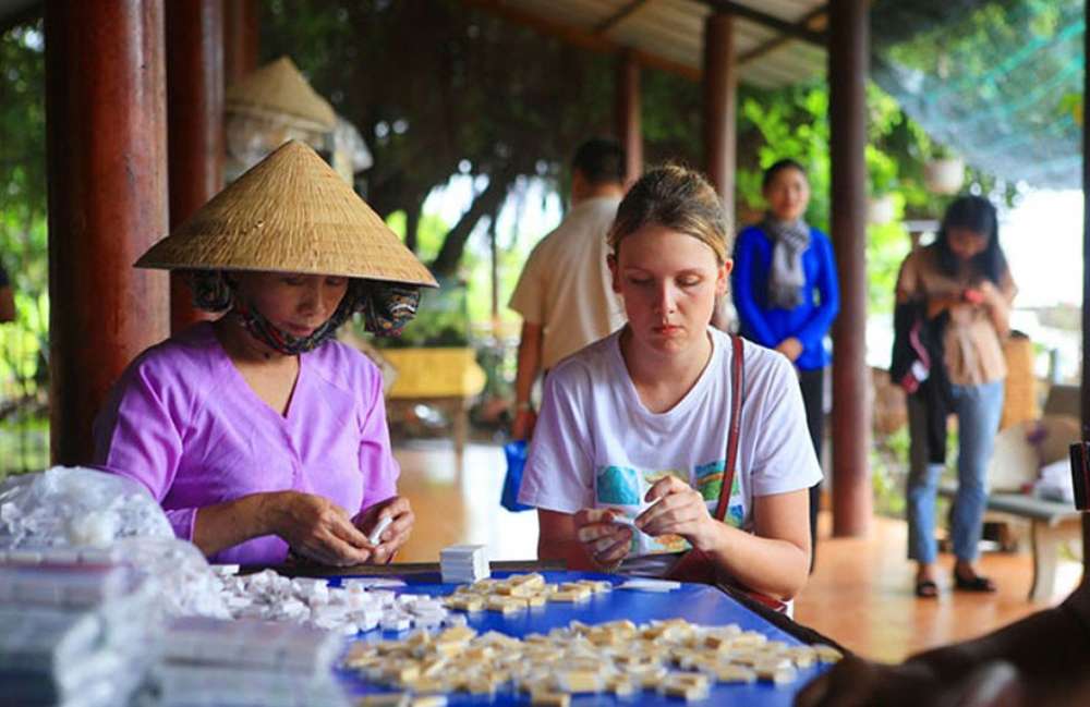 Du khách trải nghiệm gói kẹo dừa