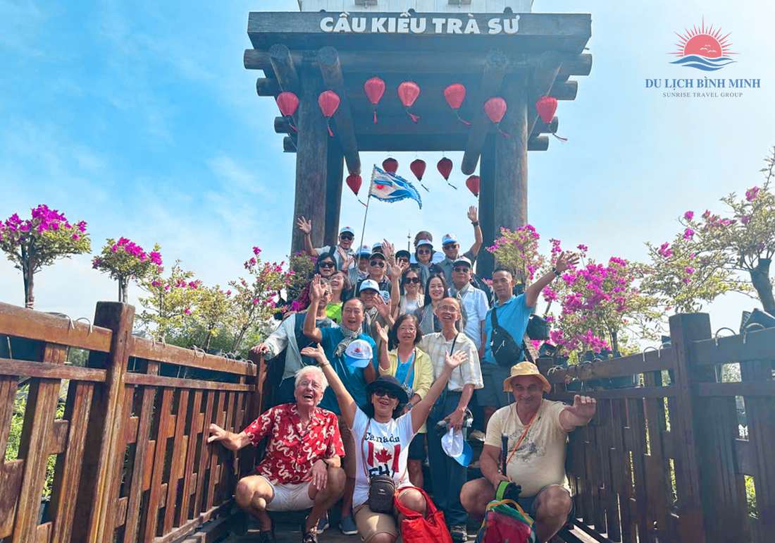 Đoàn khách Du Lịch Bình Minh vẫy tay trên Cầu Kiều Trà Sư với lồng đèn đỏ và hoa giấy, rừng tràm Trà Sư An Giang