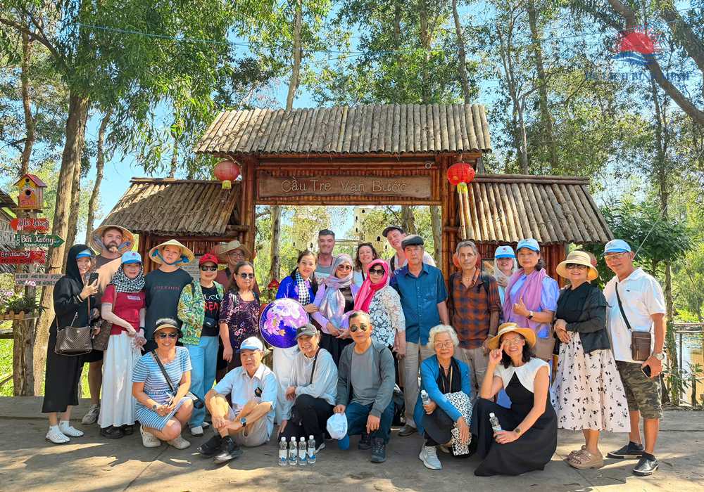 Đoàn khách Du Lịch Bình Minh trước cổng Cầu Tre Vạn Bước — cây cầu tre vạn bước nổi tiếng của rừng tràm Trà Sư An Giang