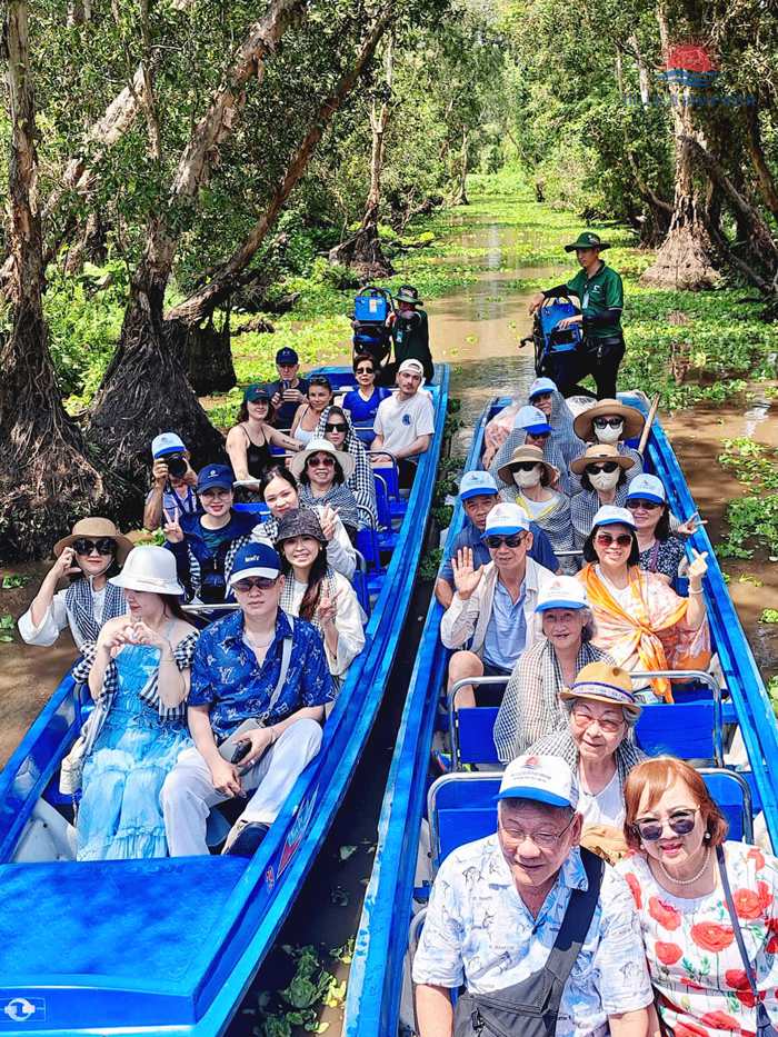 Du khách đi xuồng máy len giữa hai hàng cây tràm trên kênh nước phủ bèo xanh ở rừng tràm Trà Sư An Giang