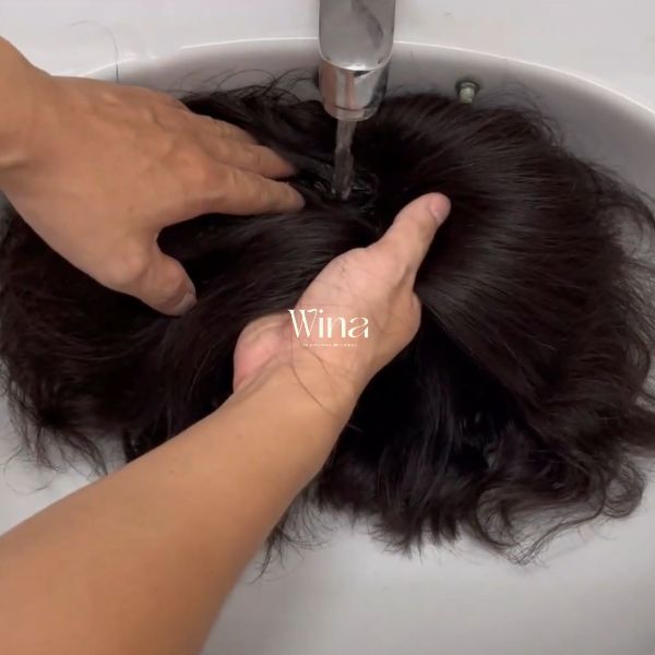Đặt tóc giả vào chậu hoặc bồn rửa và xả nhẹ nhàng với nước mát