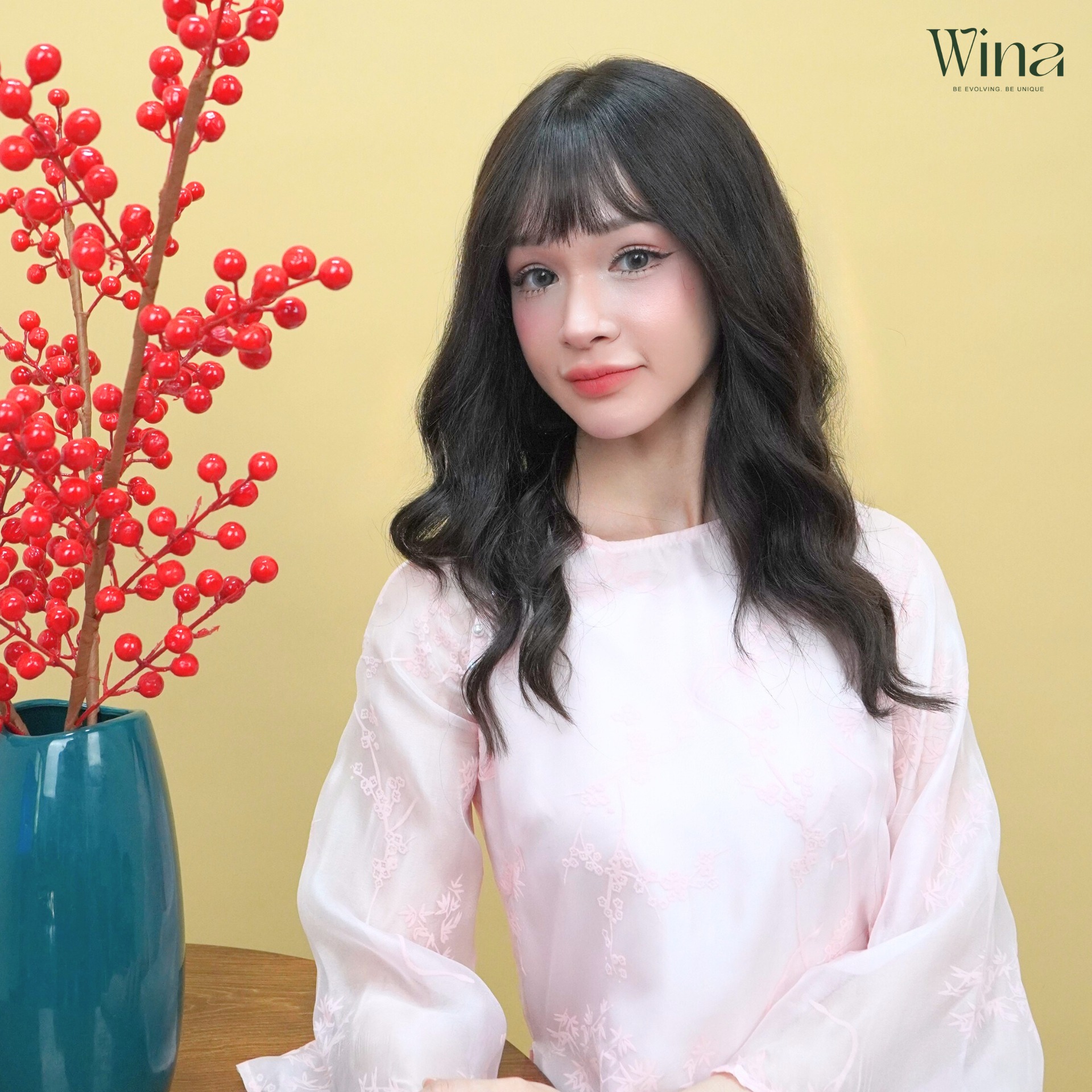 Những lọn tóc giả uốn nhẹ ôm lấy gương mặt, che đi những đường nét cứng nhắc và làm nổi bật đường nét thanh tú