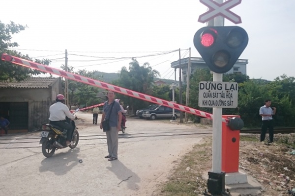 hình ảng người đàn ông đi xe máy qua rào chắn ngang