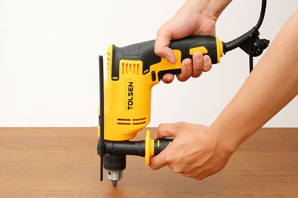 Khoan lỗ neo là bước quan trọng để cố định két sắt chắc chắn