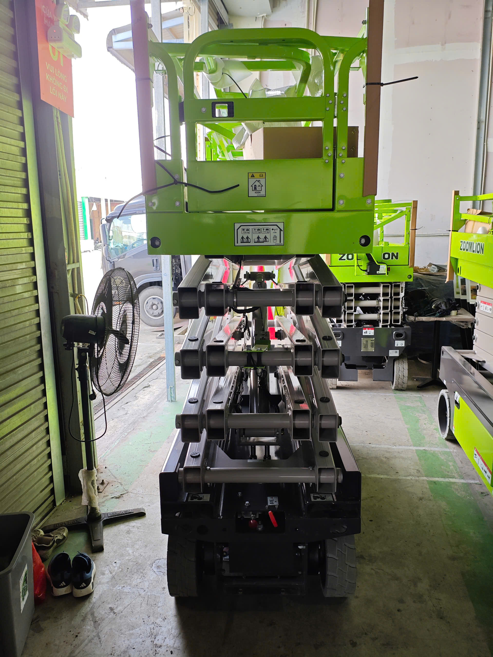 Xe nâng người cắt kéo Zoomlion đang được vận hành trong một nhà xưởng lớn, thể hiện sự linh hoạt và an toàn.