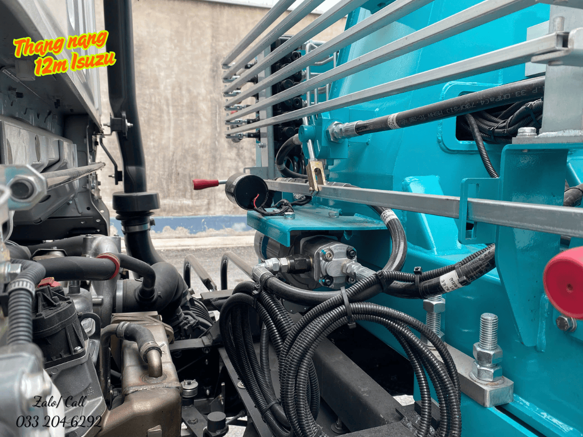 Hai công nhân mặc đồ bảo hộ với dây an toàn đang thao tác trên giỏ của xe nâng người, cho thấy không gian làm việc an toàn và chắc chắn.