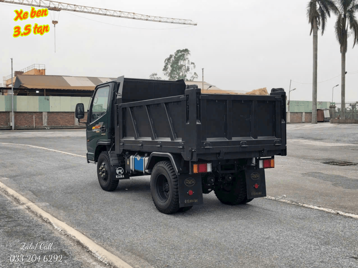 Toàn cảnh xe tải ben Hoa Mai 3.48 tấn model HD3480A-E5TD màu xanh đặc trưng, đậu trên nền đường bê tông.
