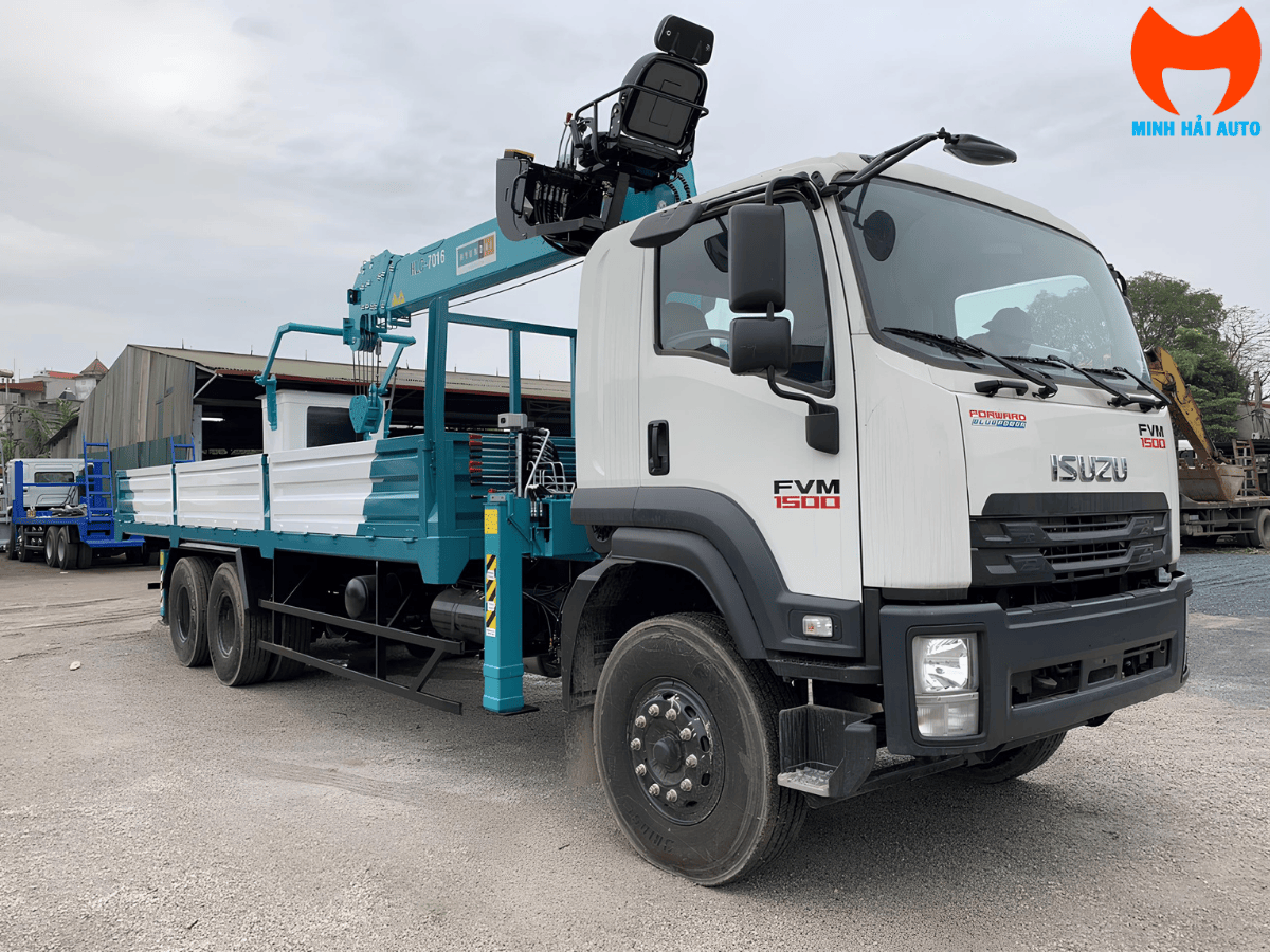 Toàn cảnh xe tải Isuzu FVR34LE5 màu trắng gắn cẩu Hyundai 5 tấn HLC-5014 màu xanh tại công trường xây dựng.