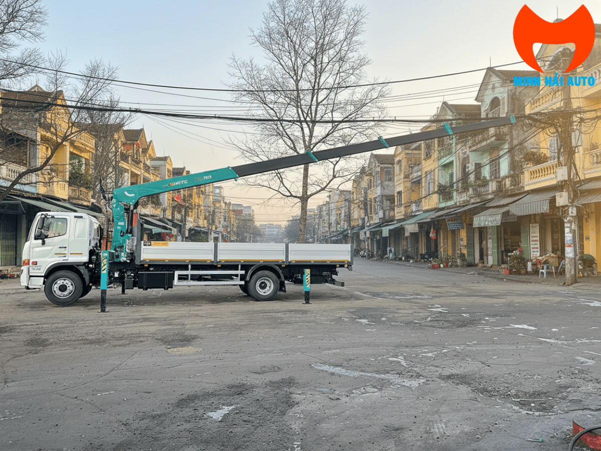 Xe cẩu Hino 500 6 tấn của Minh Hải Auto đang thực hiện bốc dỡ hàng hóa nặng tại công trình xây dựng.