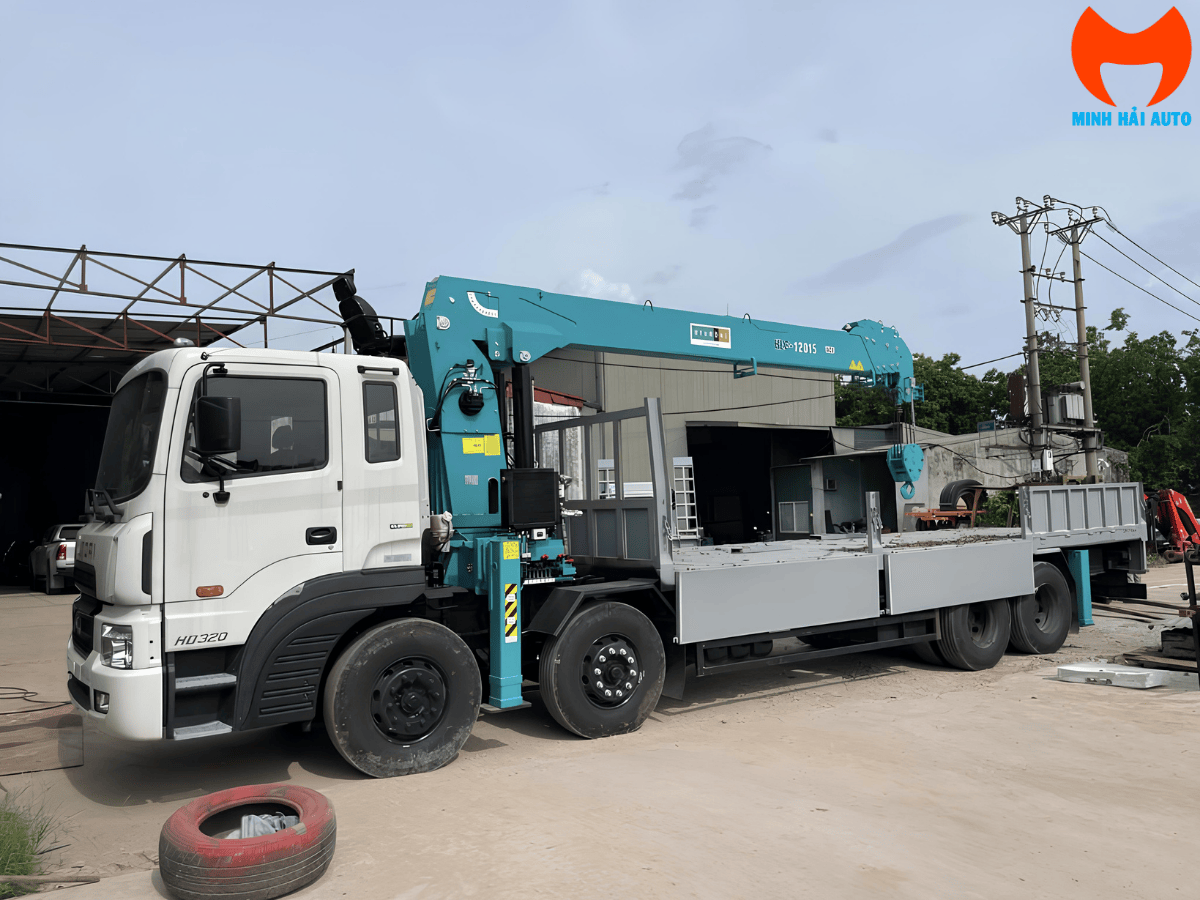 Xe cẩu thùng 12 tấn Hyundai HD320 màu trắng, gắn cẩu tự hành, đậu tại bãi xe Minh Hải Auto.