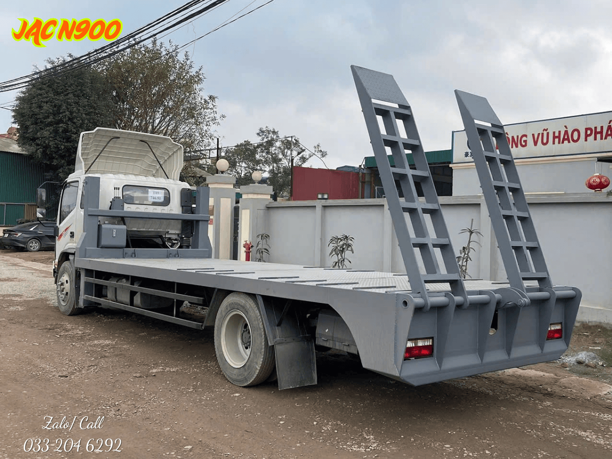 Xe chở máy công trình JAC N900 đang vận chuyển an toàn một chiếc máy xúc đào.