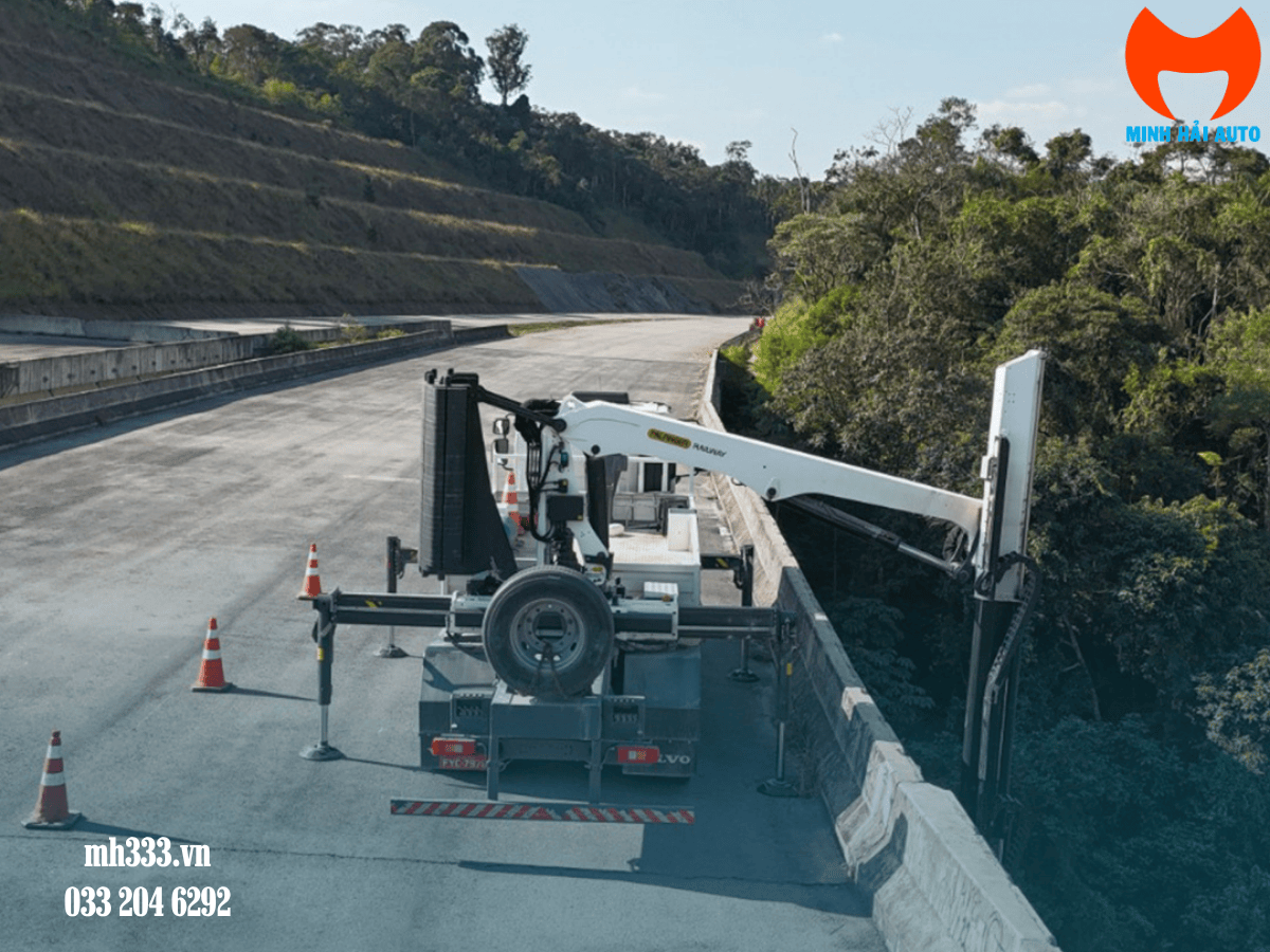 Xe kiểm tra cầu PK 19001 được lắp đặt trên một xe tải, di chuyển trên đường với cần gấp gọn.