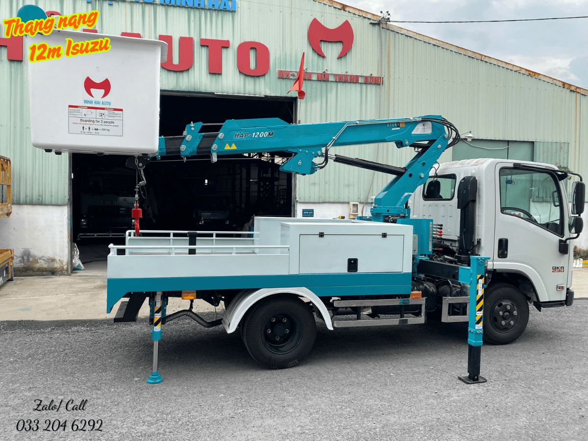 Xe nâng người 12m đang hỗ trợ nhân viên công ty cây xanh cắt tỉa cành cây cao trong thành phố một cách an toàn và hiệu quả.