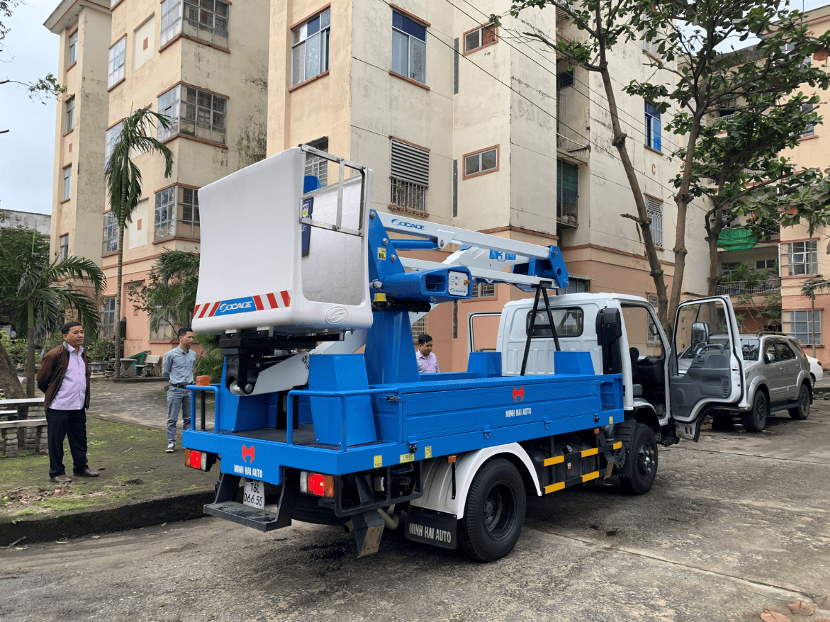 Xe nâng người tự hành cần gấp khúc Socage 13.7m lắp trên nền Isuzu QKR77F Euro 5, màu trắng, đang hoạt động nâng rổ công tác màu vàng ở độ cao, thể hiện sự mạnh mẽ và linh hoạt.