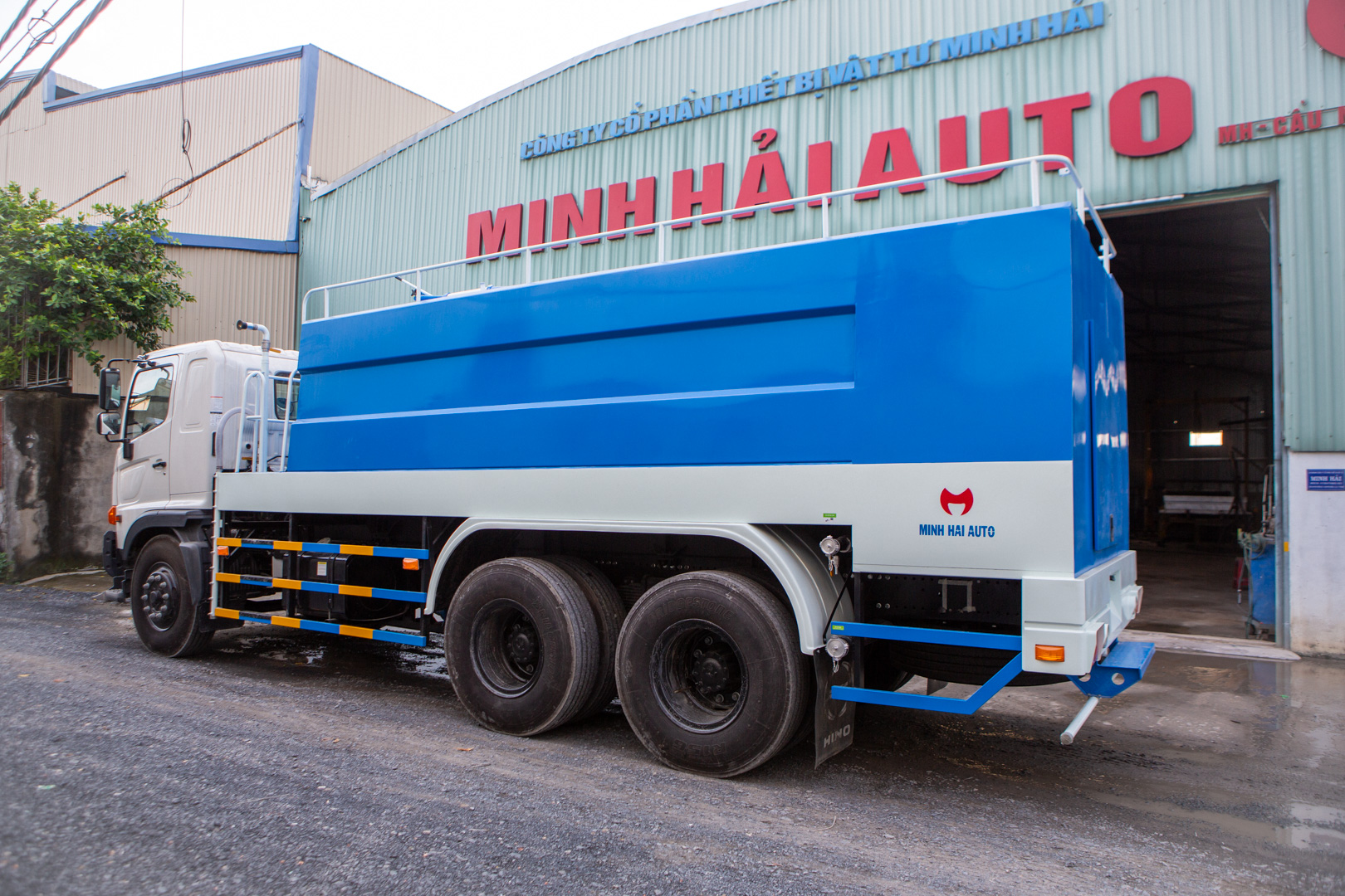 Xe phun nước rửa đường Dongfeng 14 khối (14m³, 3 chân) đang hoạt động dập bụi tại công trường xây dựng.