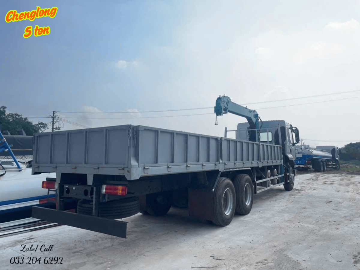 Xe tải gắn cẩu Chenglong M3 5 tấn đang thực hiện nâng hạ vật liệu xây dựng tại công trường, cho thấy khả năng làm việc linh hoạt và hiệu quả.