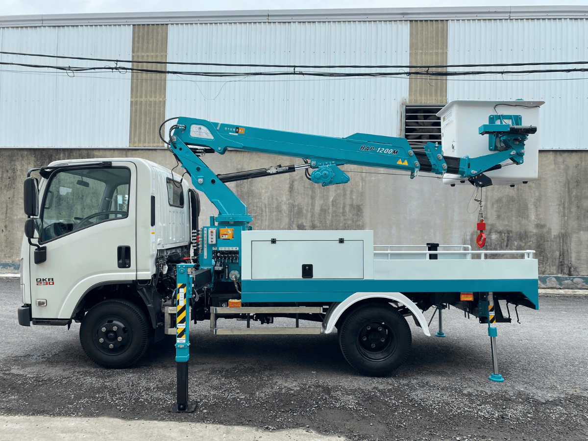 Xe tải Isuzu gắn rổ nâng người 12m đang vươn cần thẳng đứng, sẵn sàng cho công việc tại công trường.
