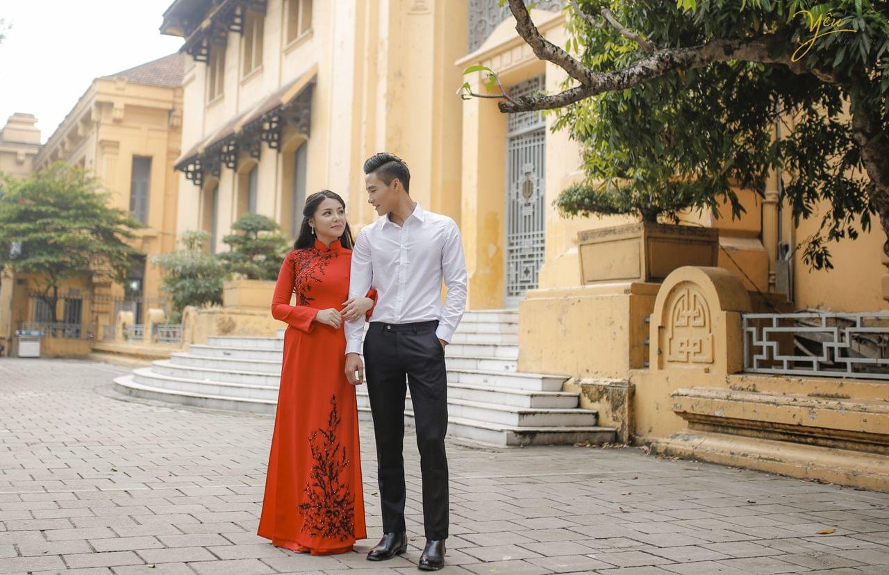 ảnh chụp cưới cô dâu mặc áo dài đỏ nép sát vào chú rể
