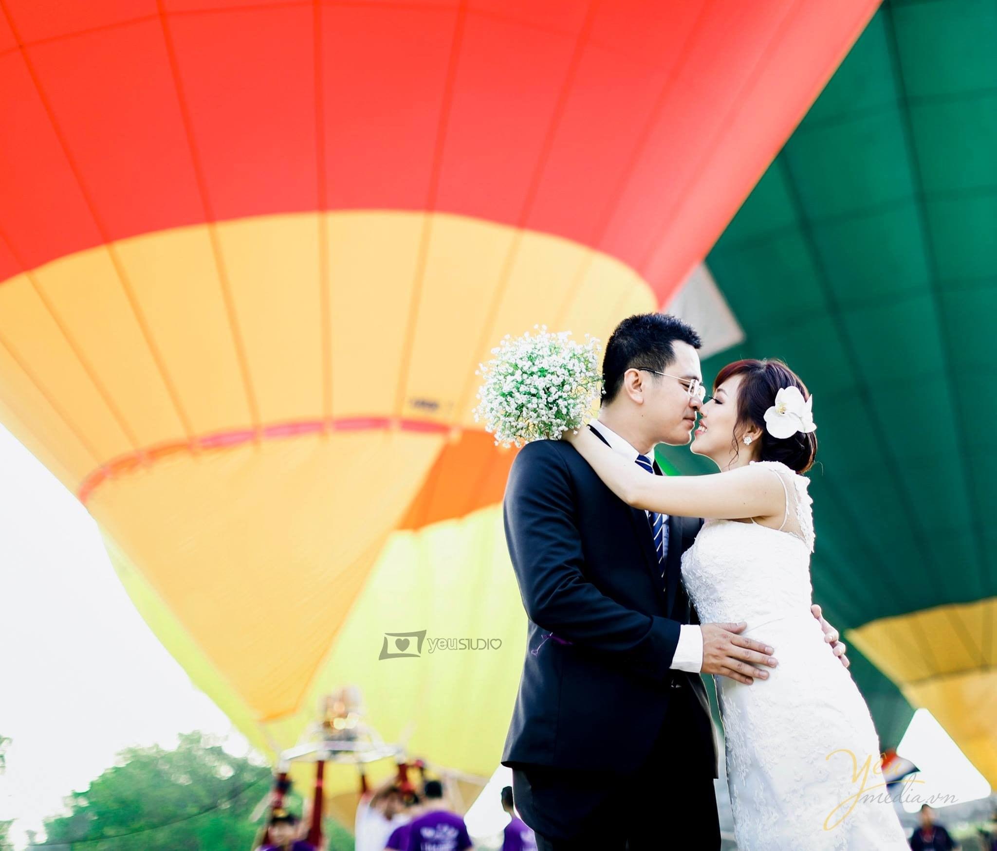 cô dâu quàng tay lên cổ chú rể ghé môi sát vào chú rể