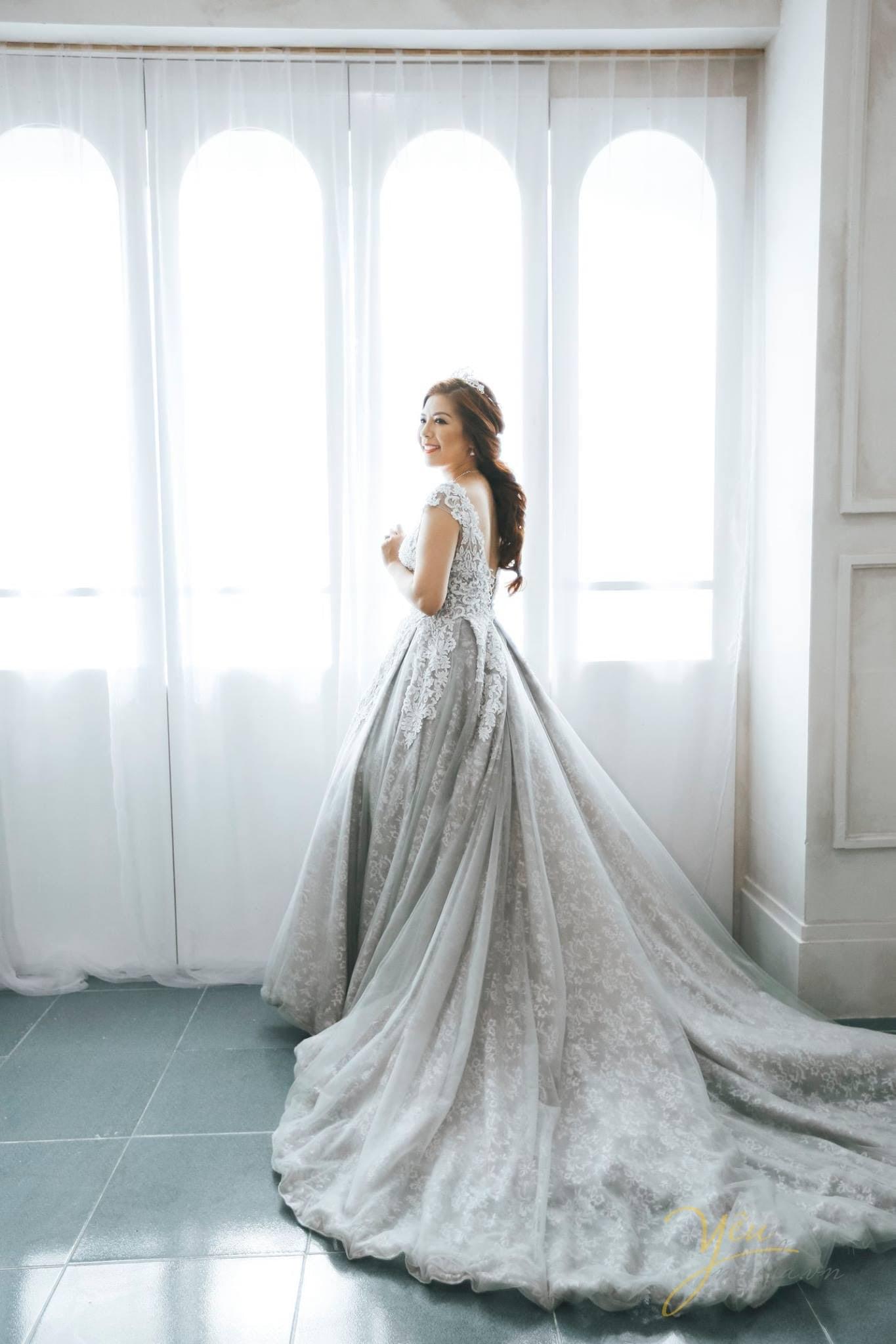 cô dâu đứng một mình bên khung cửa sổ