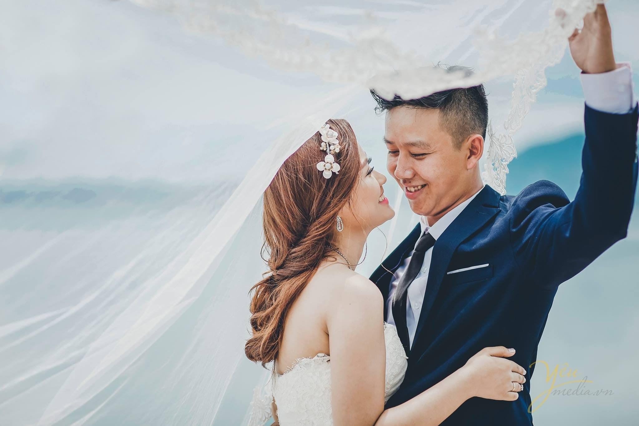 cô dâu chú rể cùng chùm đầu vào voan choàng đầu cô dâu