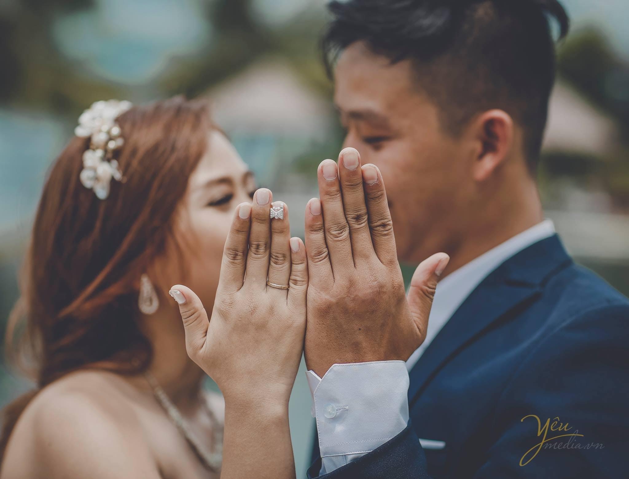 ảnh chụp cô dâu chú rể đưa 2 bàn tay đeo nhẫn lên