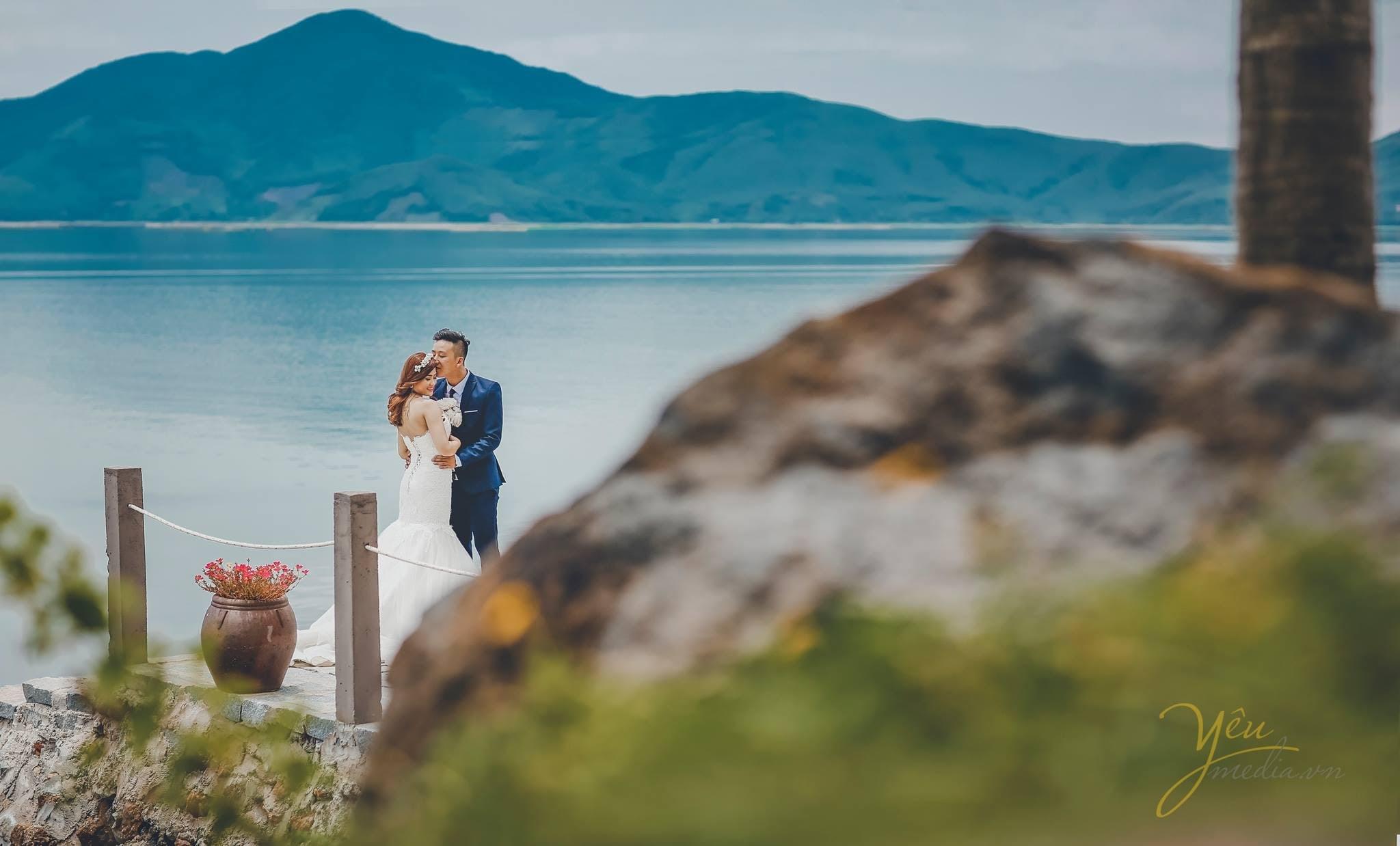 ảnh chụp cô dâu chú rể đứng trên cầu hôn nhau