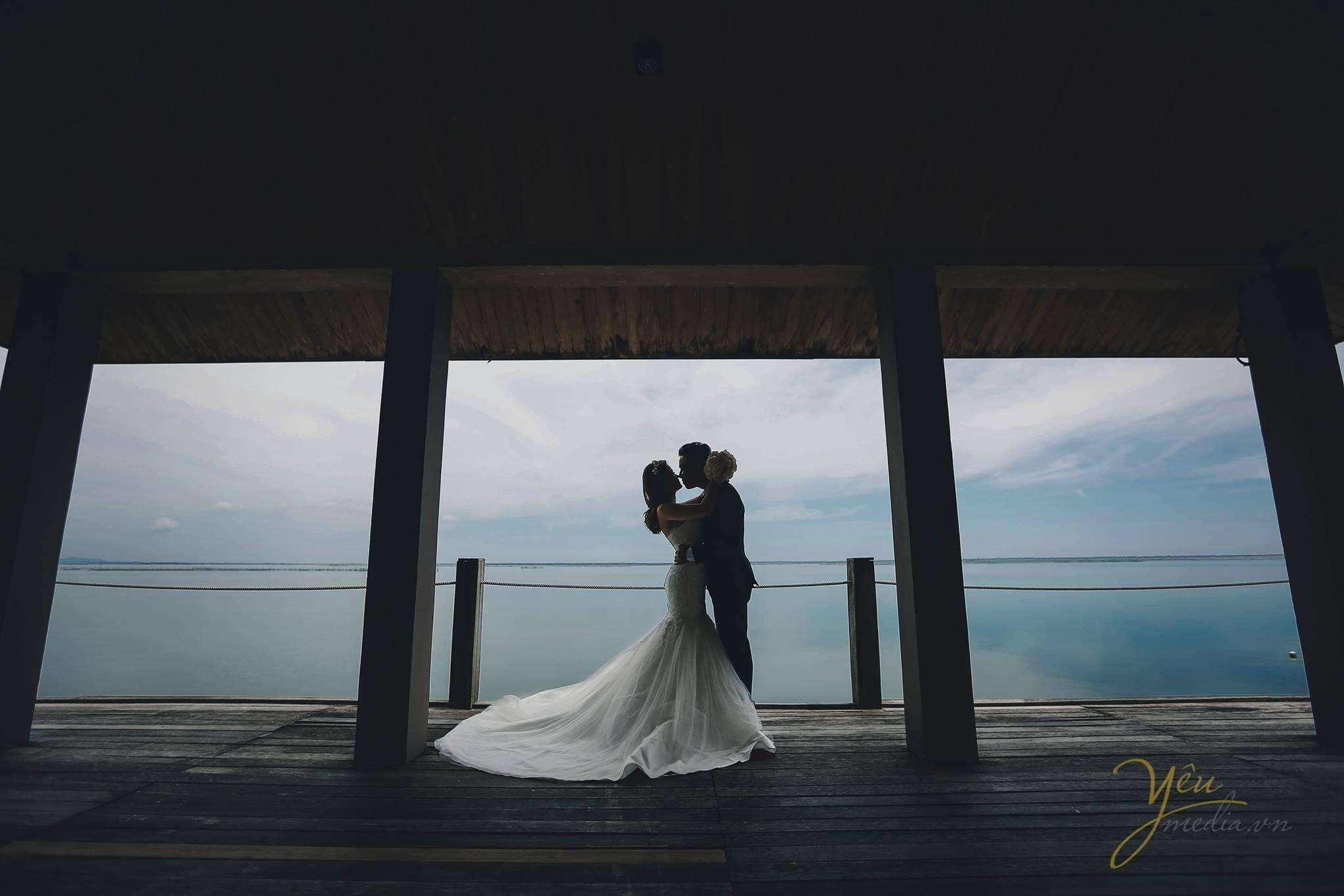 ảnh chụp cô dâu chú rể hôn nhau trên cầu nhìn ra hồ