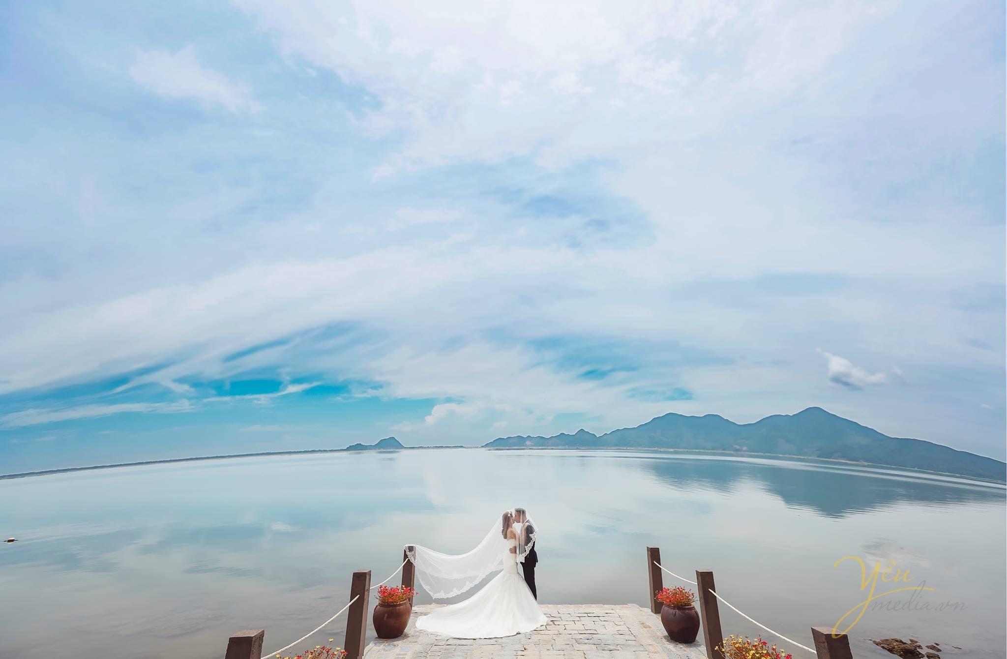 ảnh chụp từ xa cô dâu chú rể hôn nhau trên đầu cầu