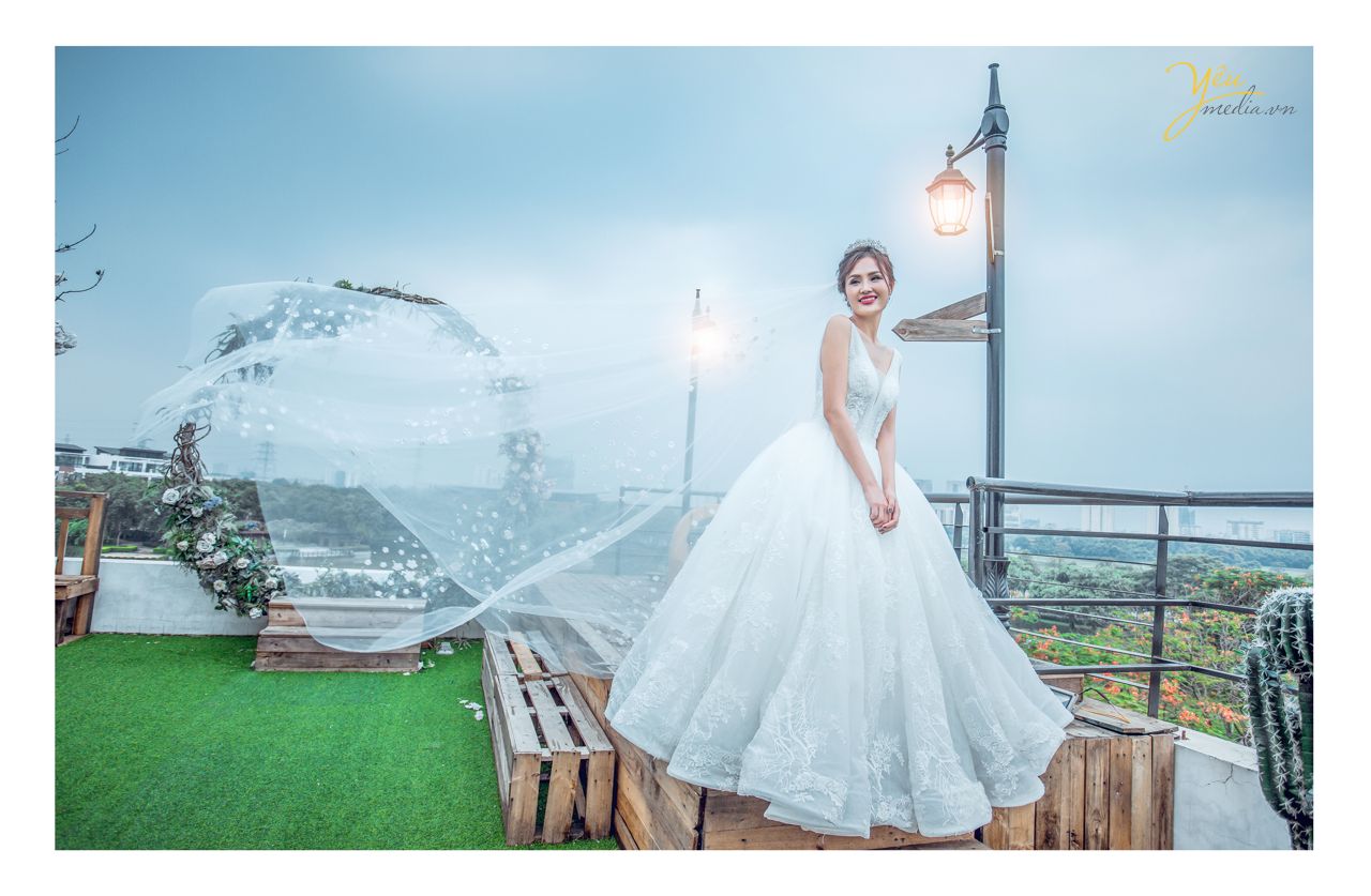 ảnh chụp cô dâu đơn cười xinh đẹp cạnh cột đèn bão