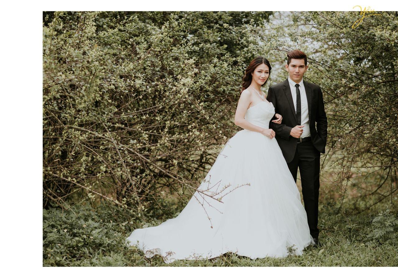 ảnh cưới ngoại cảnh cô dâu khoác tay chú rể đứng trong rừng