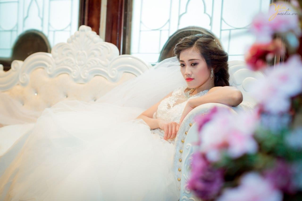ảnh cưới chụp cô dâu ngồi trên ghế salon sang trọng