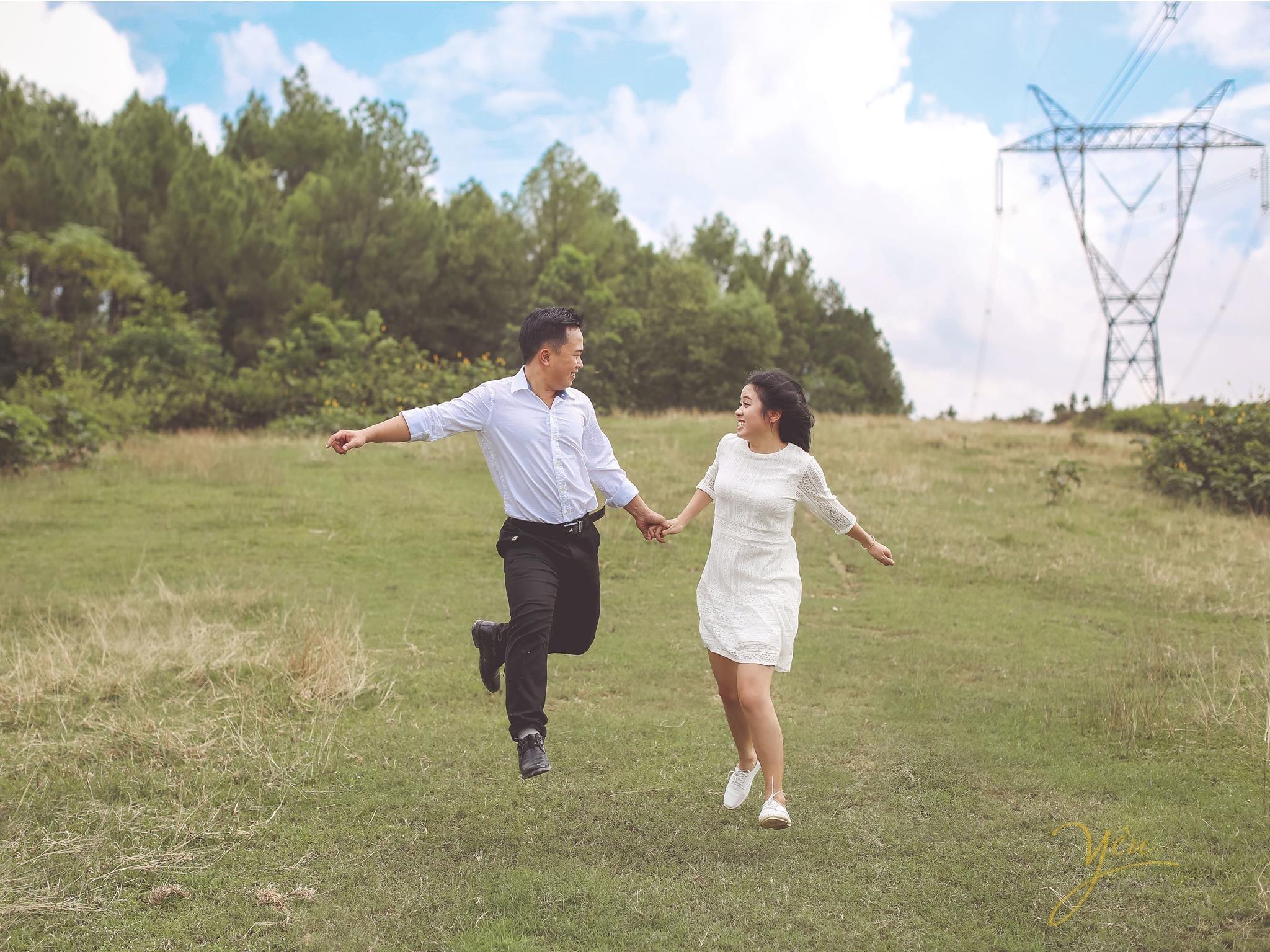ảnh chụp cô dâu chú rể nắm tay chạy trên bãi cỏ