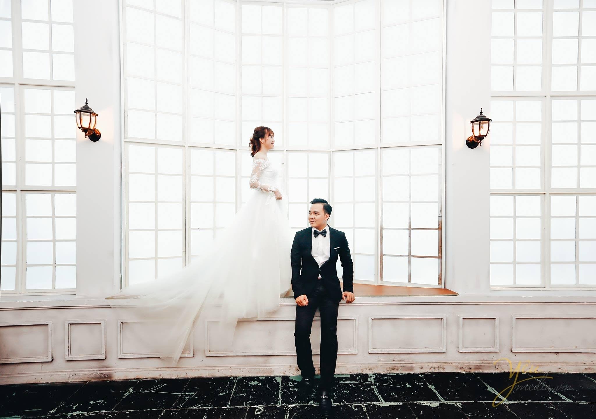 ảnh chụp cô dâu chú rể bên khung cửa