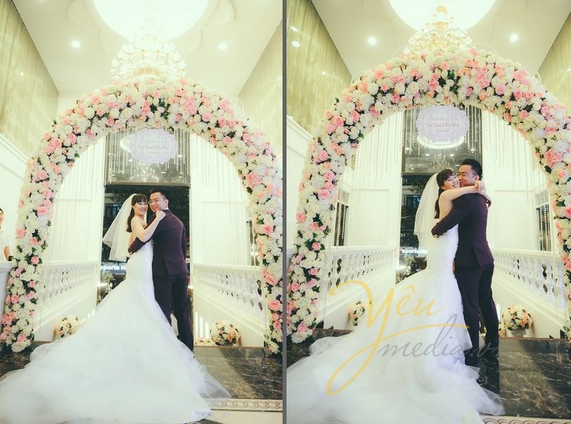 cô dâu chú rể ôm nhau tại cổng hoa lễ cưới