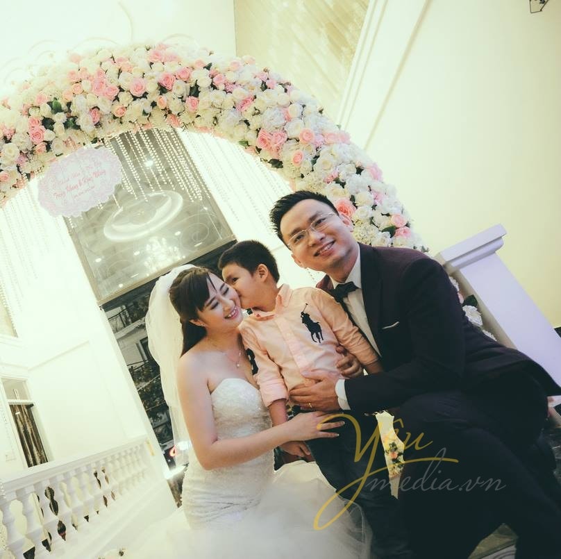 cô dâu chú rể chụp ảnh cùng em bé trong lễ cưới