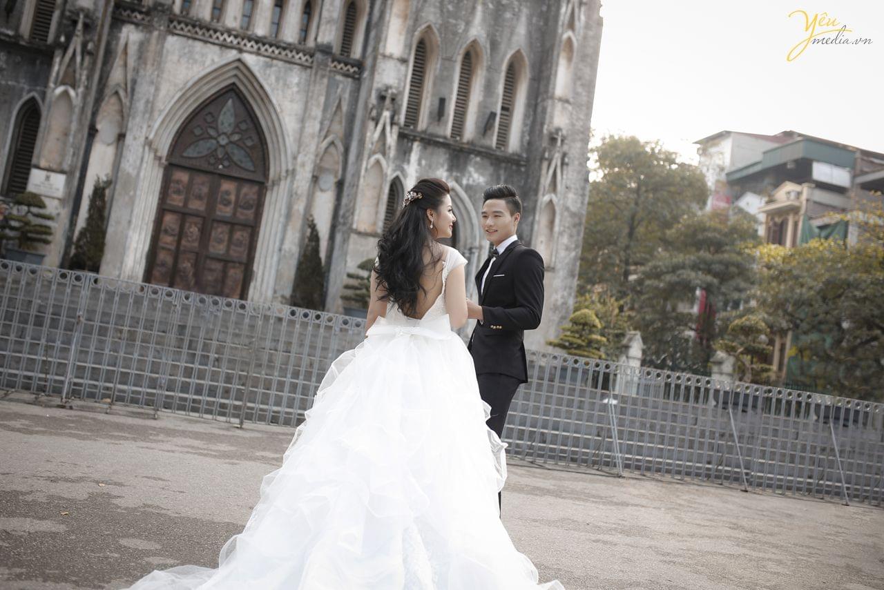 chụp ảnh cưới hiện đại váy trắng đuôi dài trước sảnh nhà thờ lớn hà nội