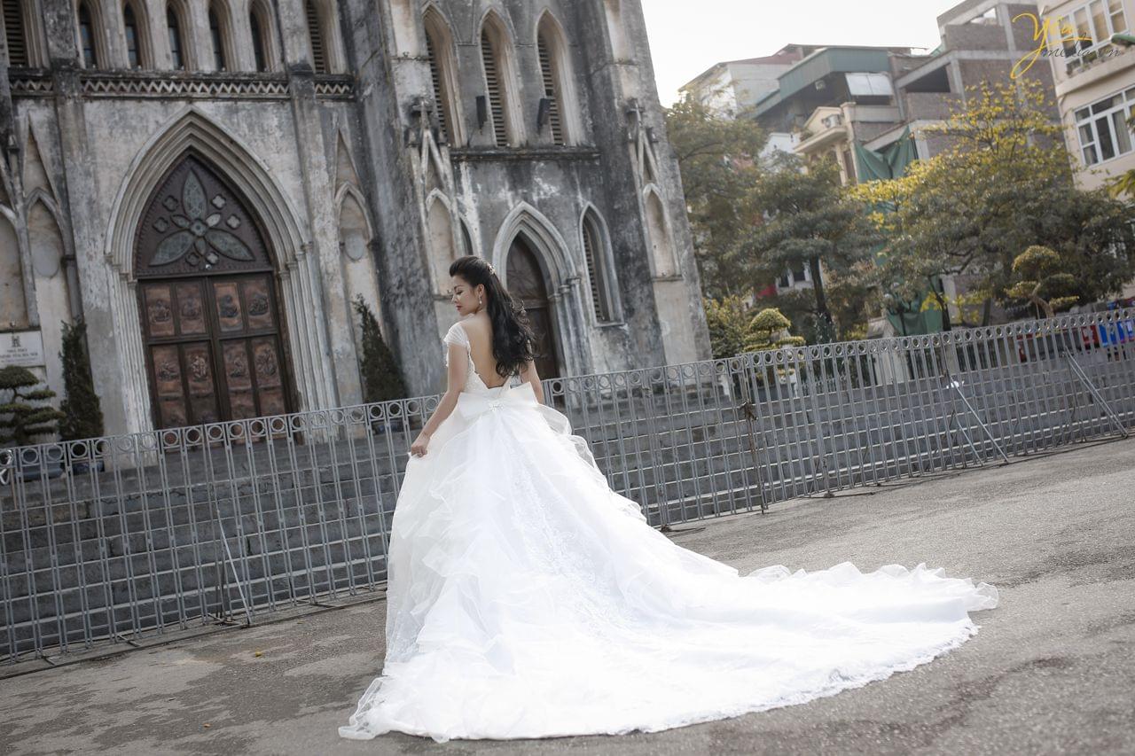 ảnh cưới cô dâu đơn chụp phía sau lưng sảnh trước nhà thờ lớn hà nội