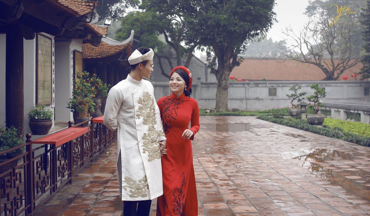 ảnh chụp cưới pre wedding áo dài đỏ cô dâu chú rể nắm tay nhau