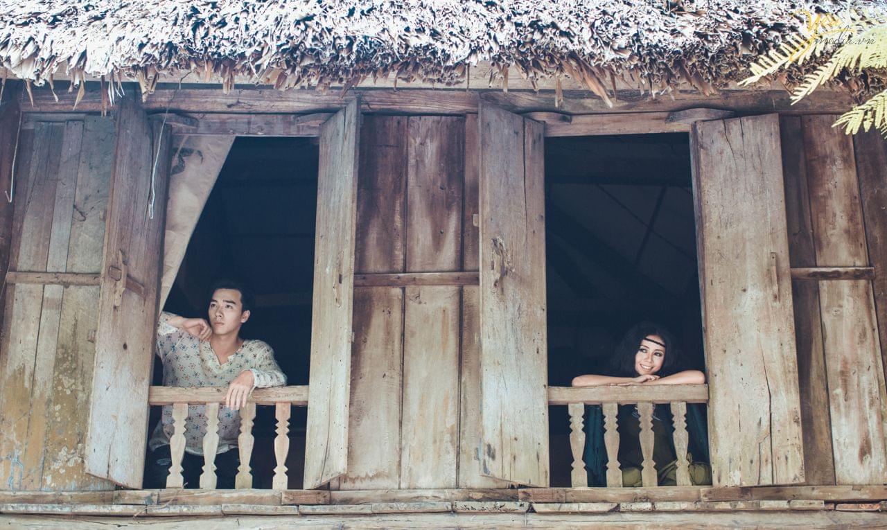 ảnh cưới chụp từ phía dưới lên cô dâu chú rể mỗi người 1 khung cửa