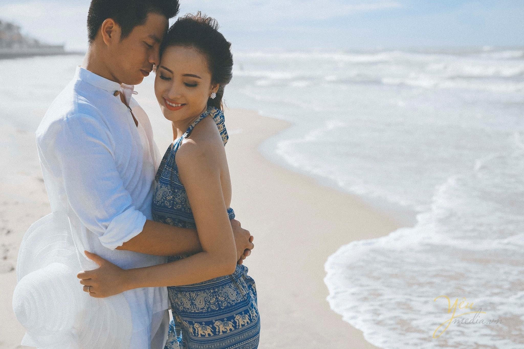 chú rể ôm cô dâu ghé sát má cô dâu