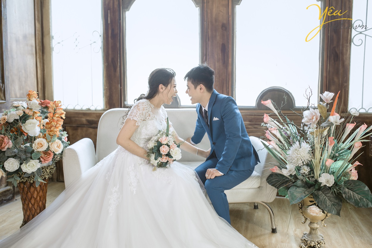 cô dâu chú rể ngồi trên ghế cười vui với nhau