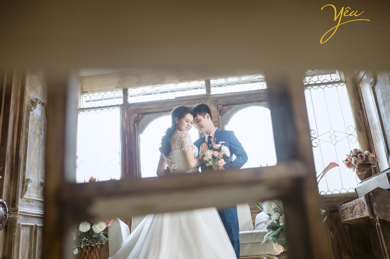 cặp đôi mới cưới chụp ảnh qua khe cửa nghệ thuật