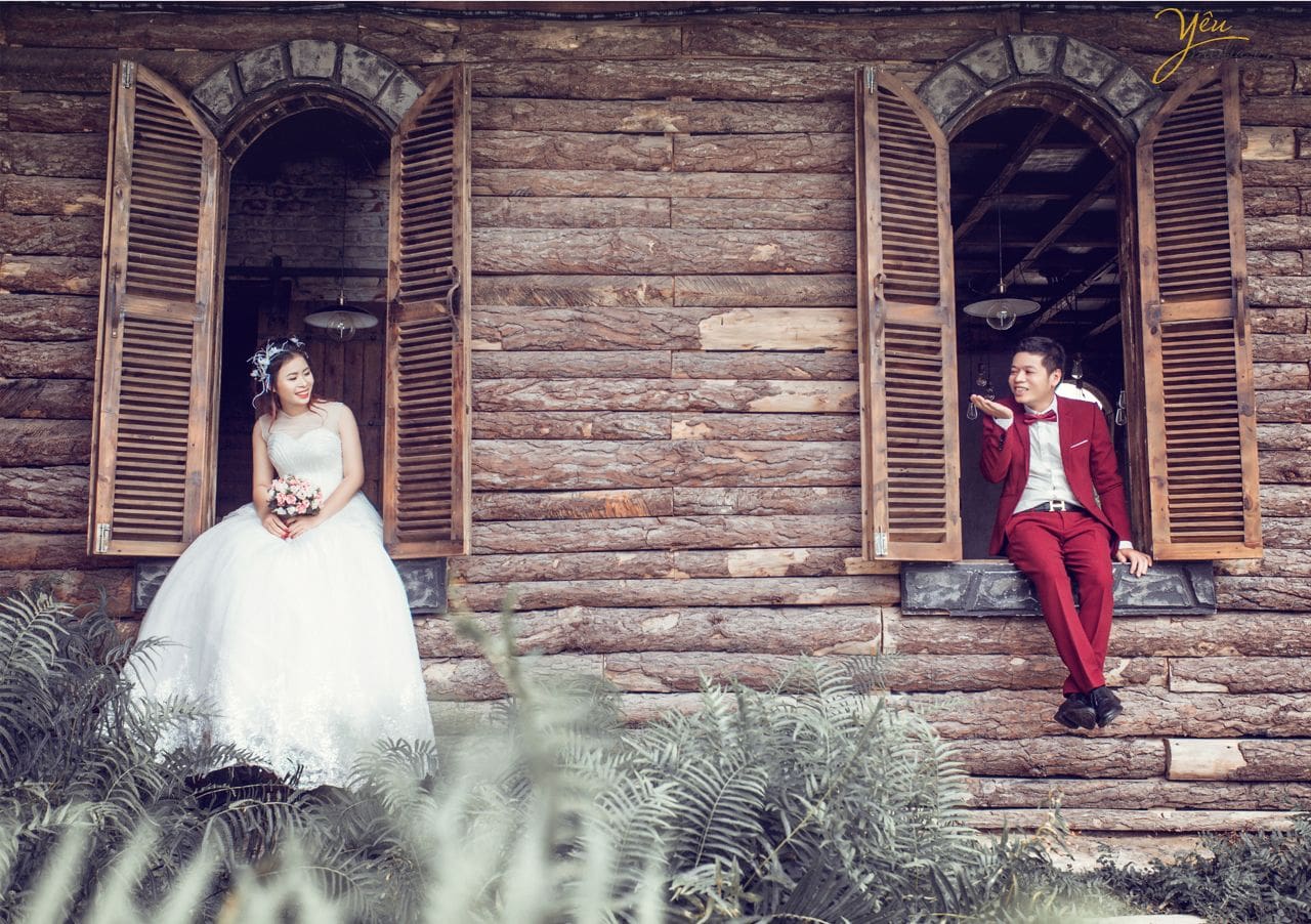 cô dâu chú rể ngồi bên bục cửa sổ nô đùa