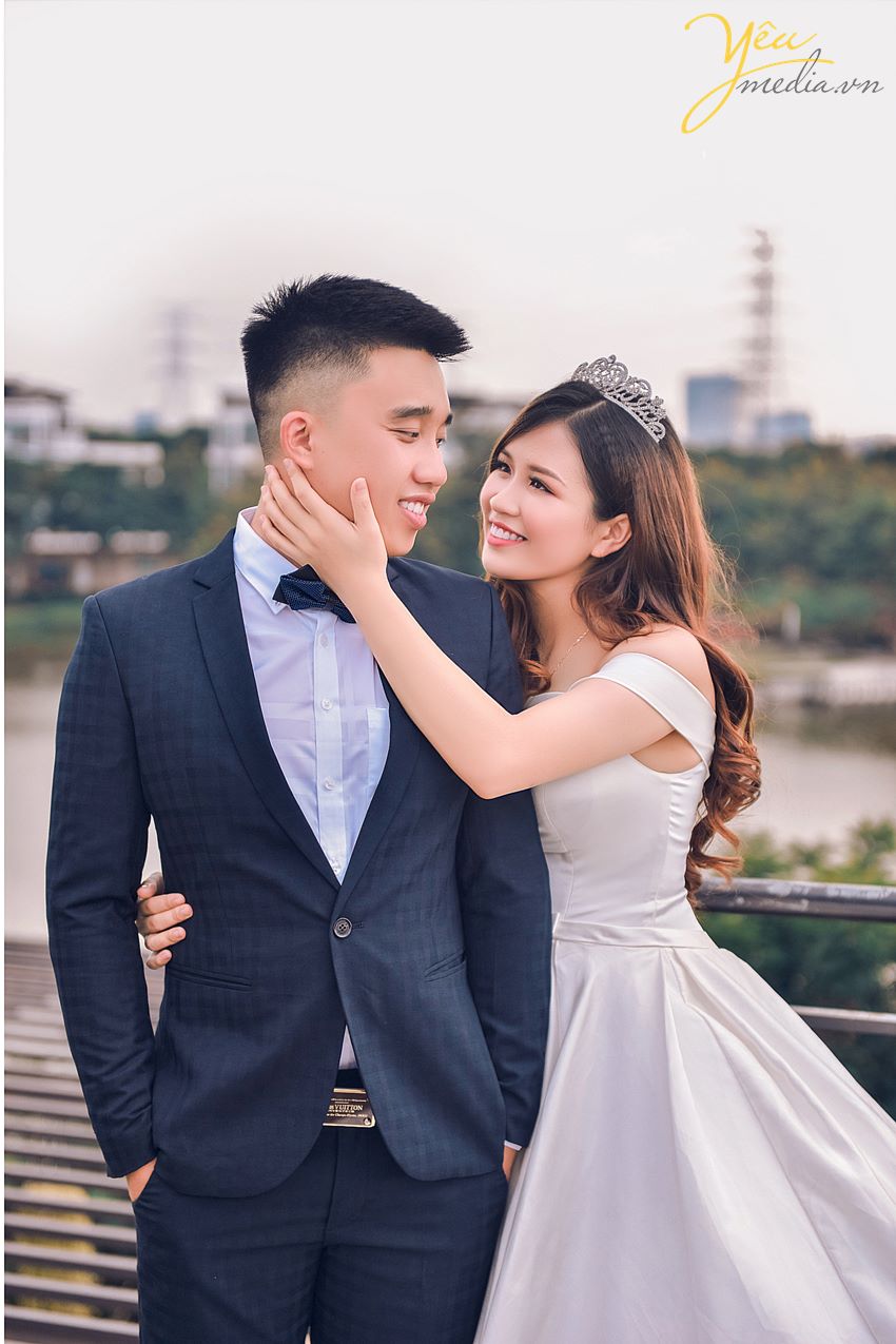 cô dâu vuốt má chú rể khi chụp ảnh