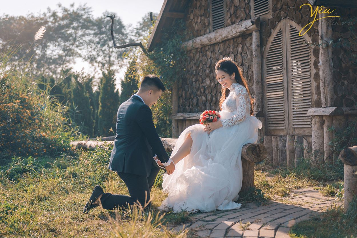 chú rể nâng gót giày cho cô dâu