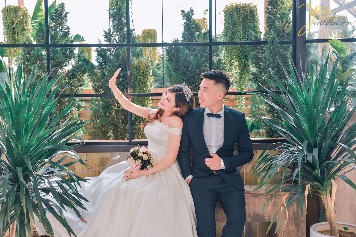 cặp đôi chụp ảnh cưới bên ô cửa sổ to